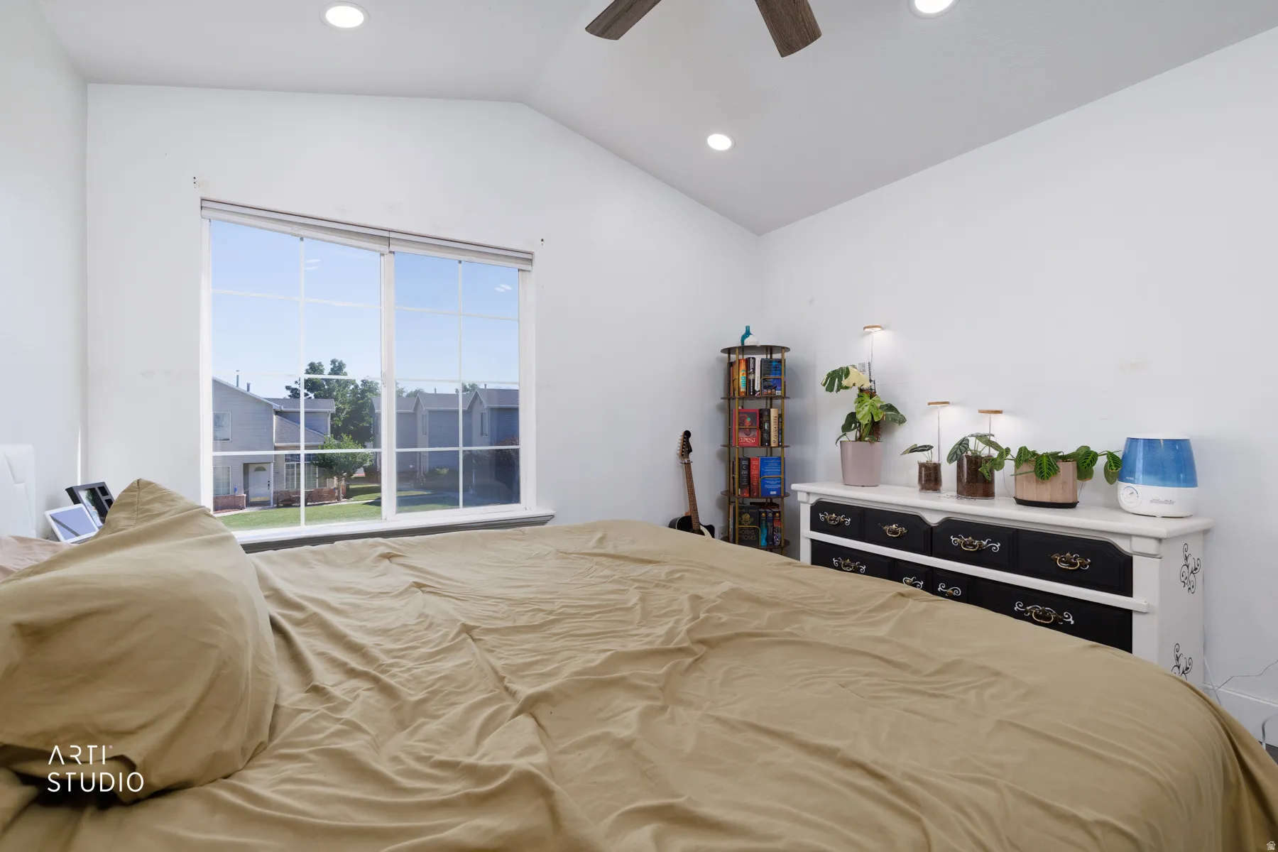 Spacious room featuring vaulted ceilings, a prominent multi-pane window, recessed lighting, and a ceiling fan