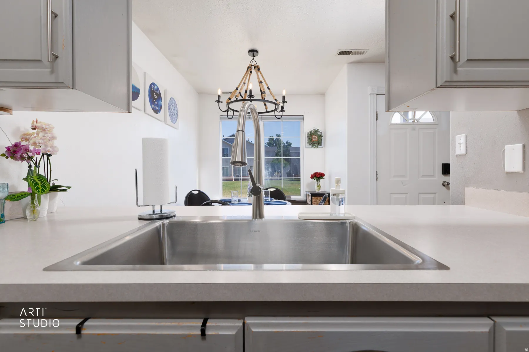 Stainless steel sink with a high-arc faucet, set into a light-toned countertop