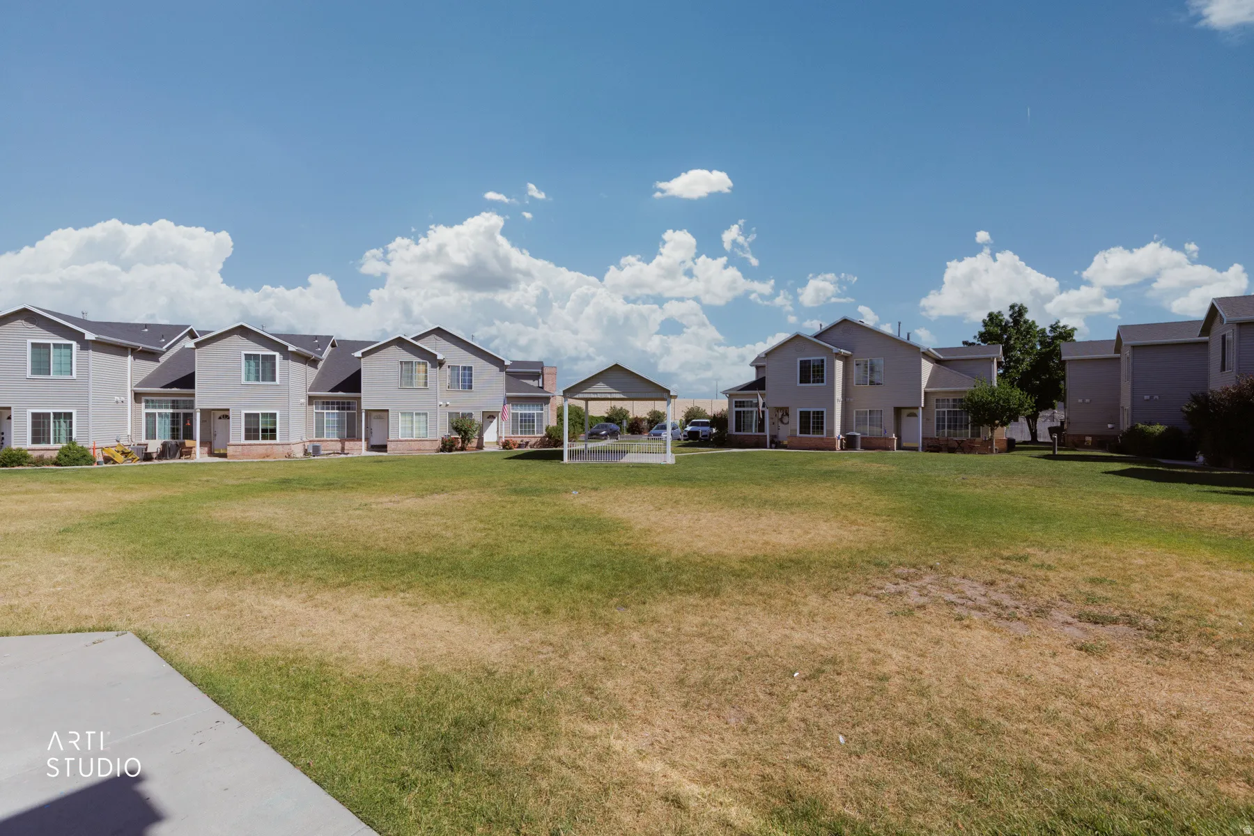 Expansive green space featuring a large lawn area and surrounding residential properties