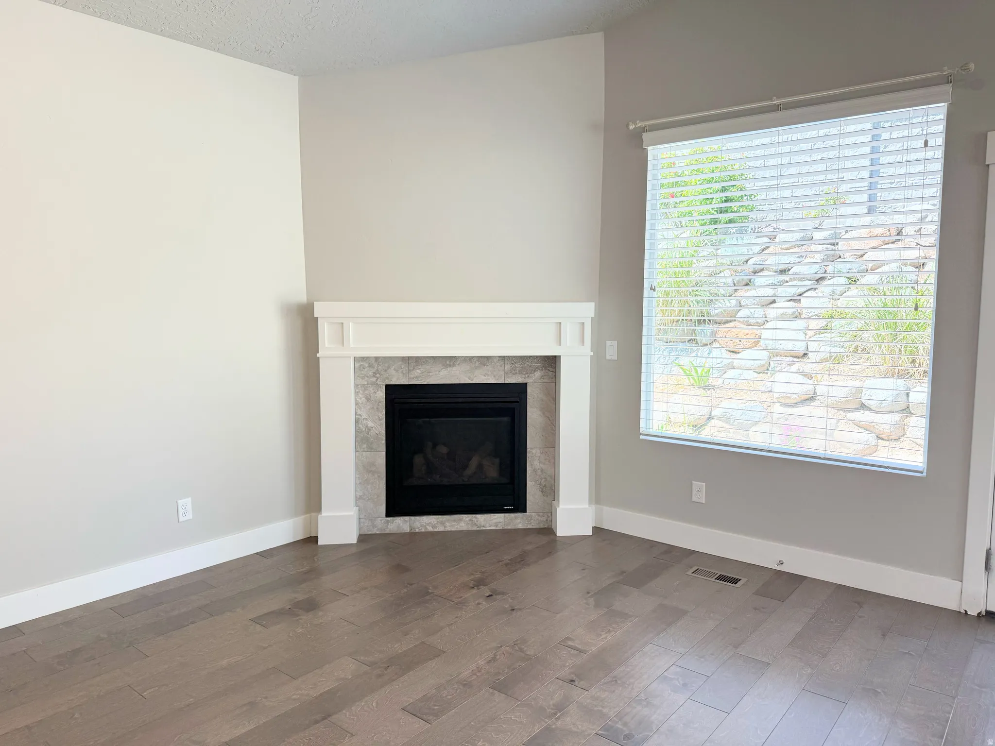 Corner gas fireplace with a white mantel and tile surround