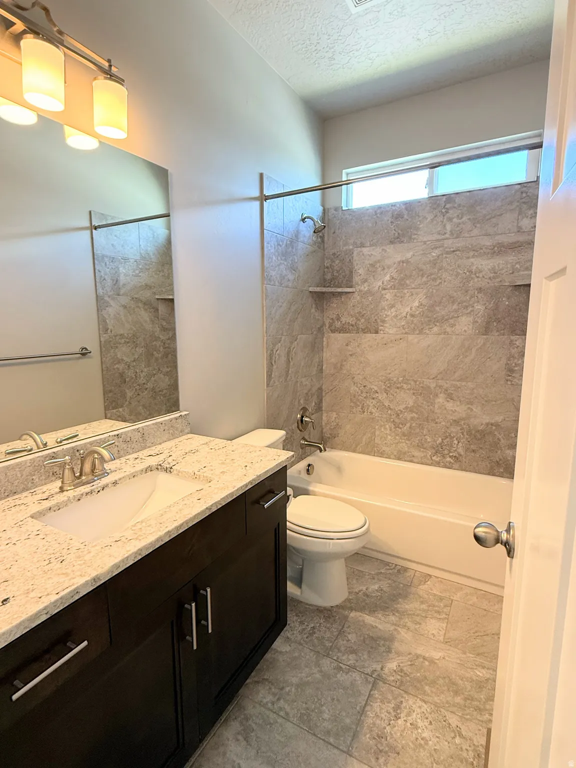 Bathroom #2 featuring a dark wood-finish vanity with a light-toned countertop, an undermount sink, and a large wall mirror