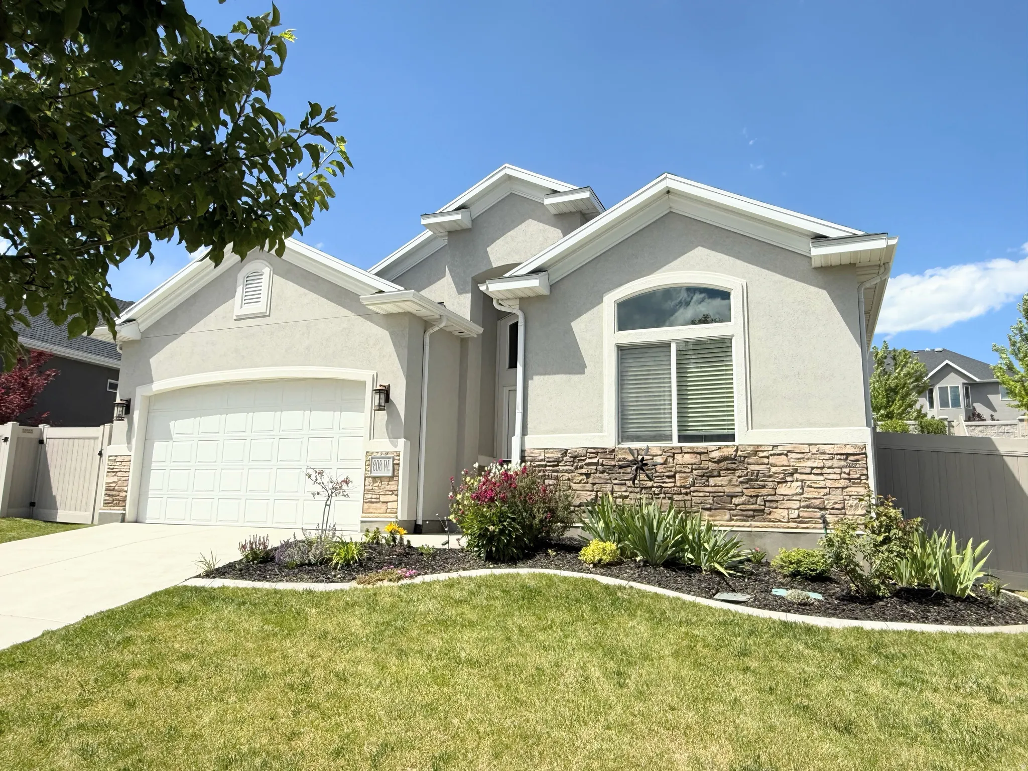 Contemporary stucco exterior with stone accents, featuring a two-car garage