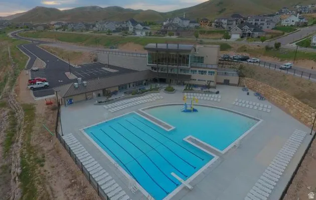 Expansive Traverse Mountain aquatic center featuring a multi-lane lap pool, a separate recreation pool with an aquatic play structure, and ample lounge seating