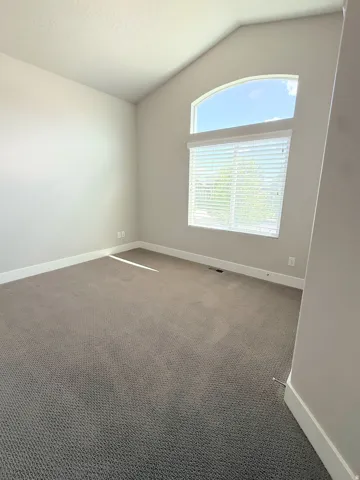 Bedroom #2 Vaulted ceiling room with a large arched window and additional rectangular window with blinds