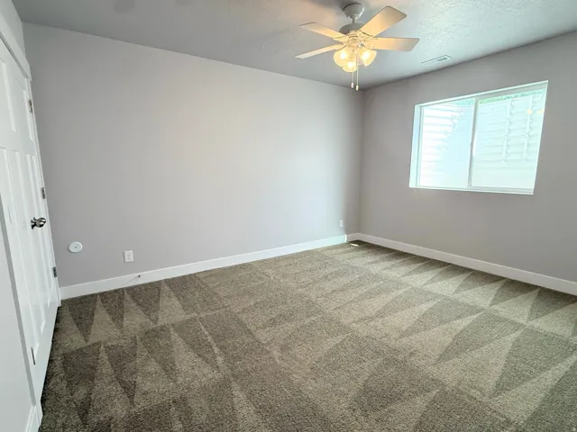 Bedroom # 6 featuring carpet flooring, neutral painted walls, a window with horizontal blinds, a white ceiling fan with integrated lighting, and white baseboards