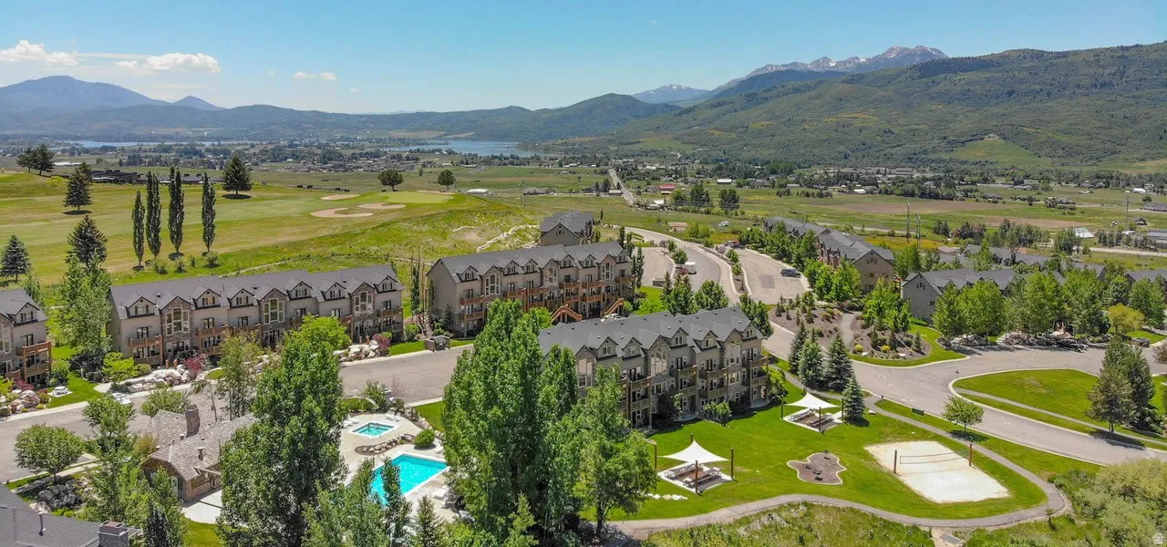 Aerial perspective showcasing the residential community, surrounding green spaces, and mountainous backdrops