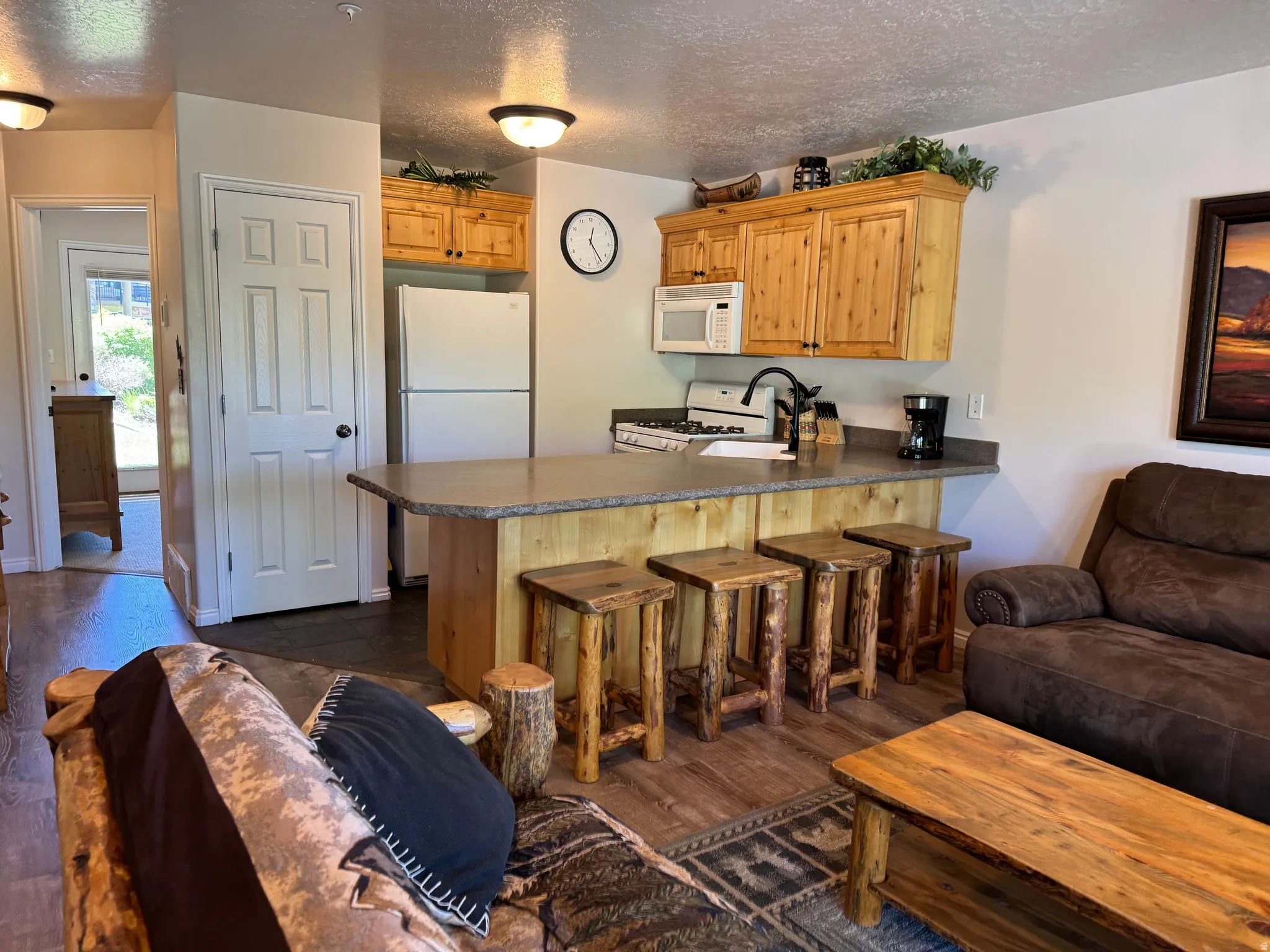 Fully stocked pantry and kitchen with wood-finish cabinetry and bar seating