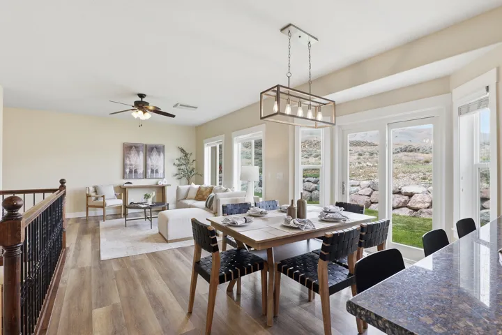 Open-concept main living area with wood-finish flooring, a contemporary ceiling fan, and abundant natural light from multiple windows