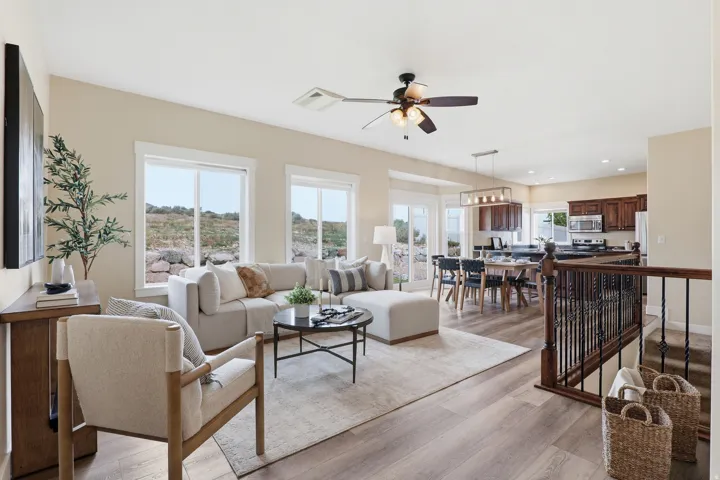 Open-concept living area with wood-finish flooring, recessed lighting, and multiple large windows