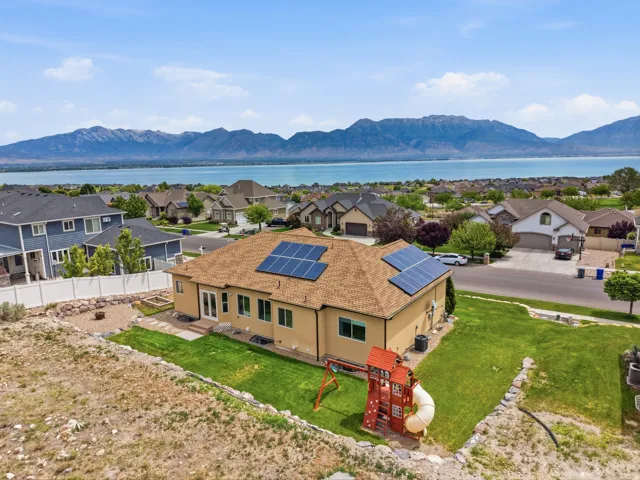 Property featuring a stucco exterior and a shingle roof with integrated solar panels