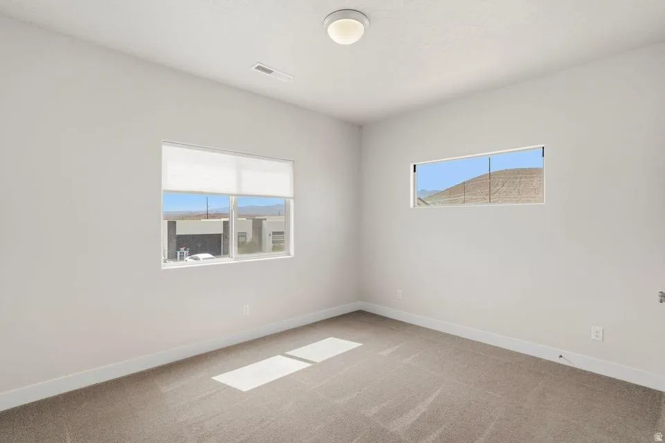 Neutral tone wall paint with white trim, complemented by light brown carpet flooring