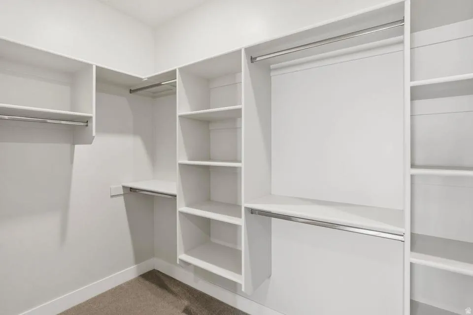 Custom closet system featuring white shelving and chrome hanging rods