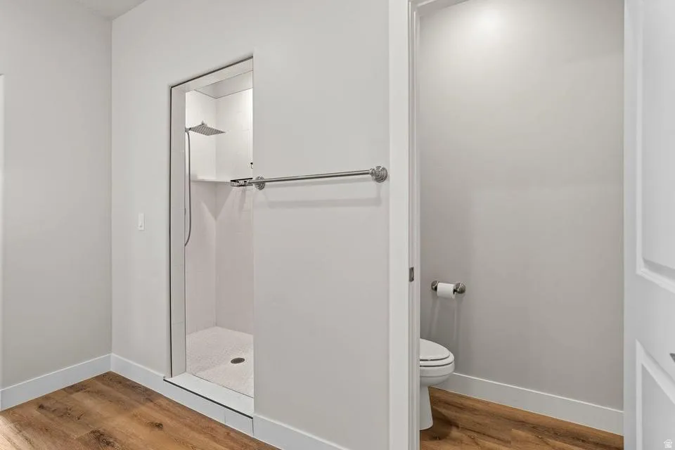 Walk-in shower with a glass enclosure, white tile surround, and a rainfall showerhead