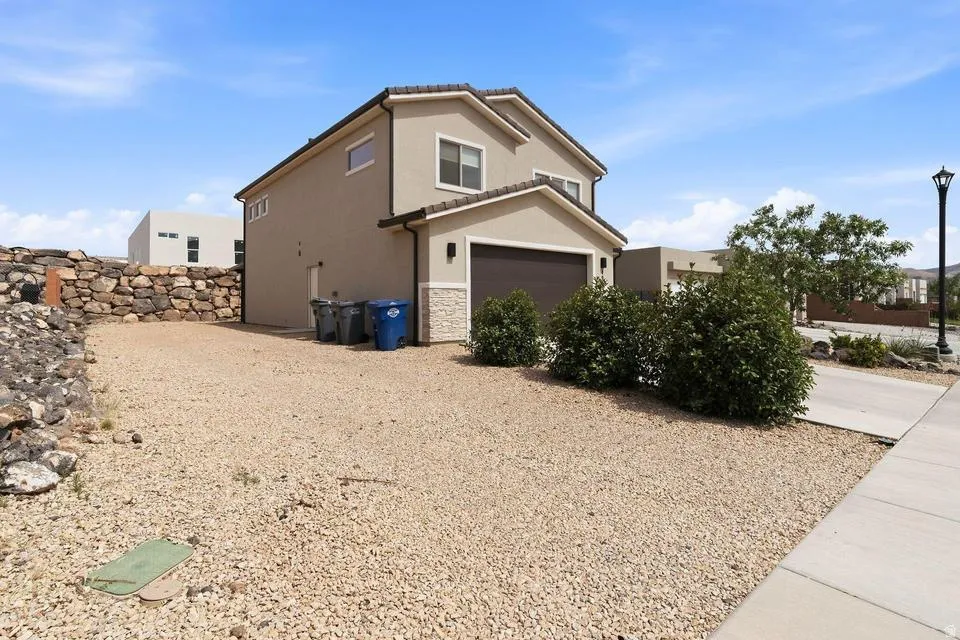 Two-story stucco exterior with an attached garage featuring a brown door