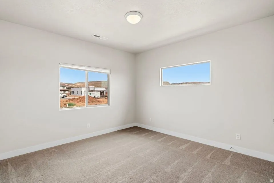 Carpeted room with light-toned walls and white baseboards
