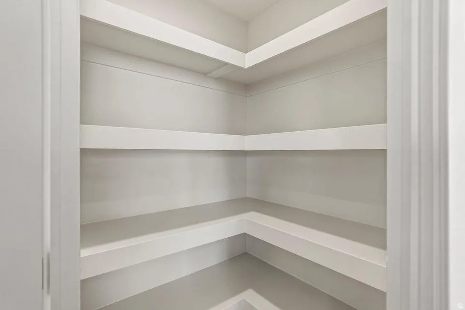 Corner pantry with multiple white-painted built-in shelves