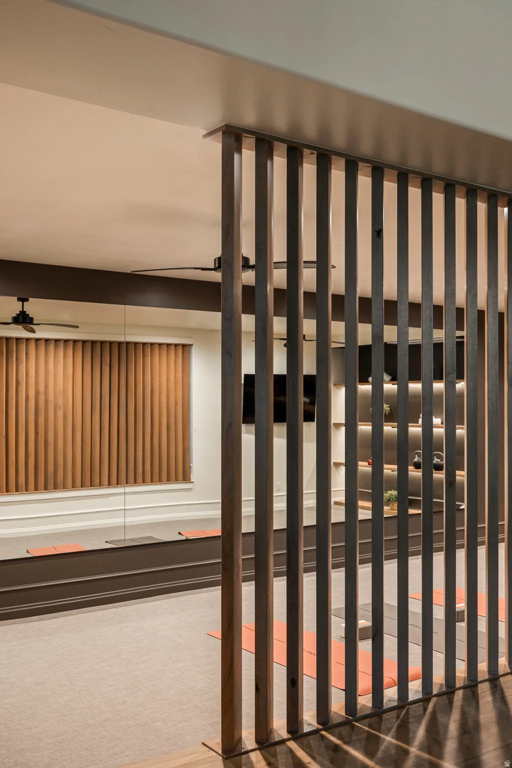 Custom wood-slat partition separating a carpeted interior space