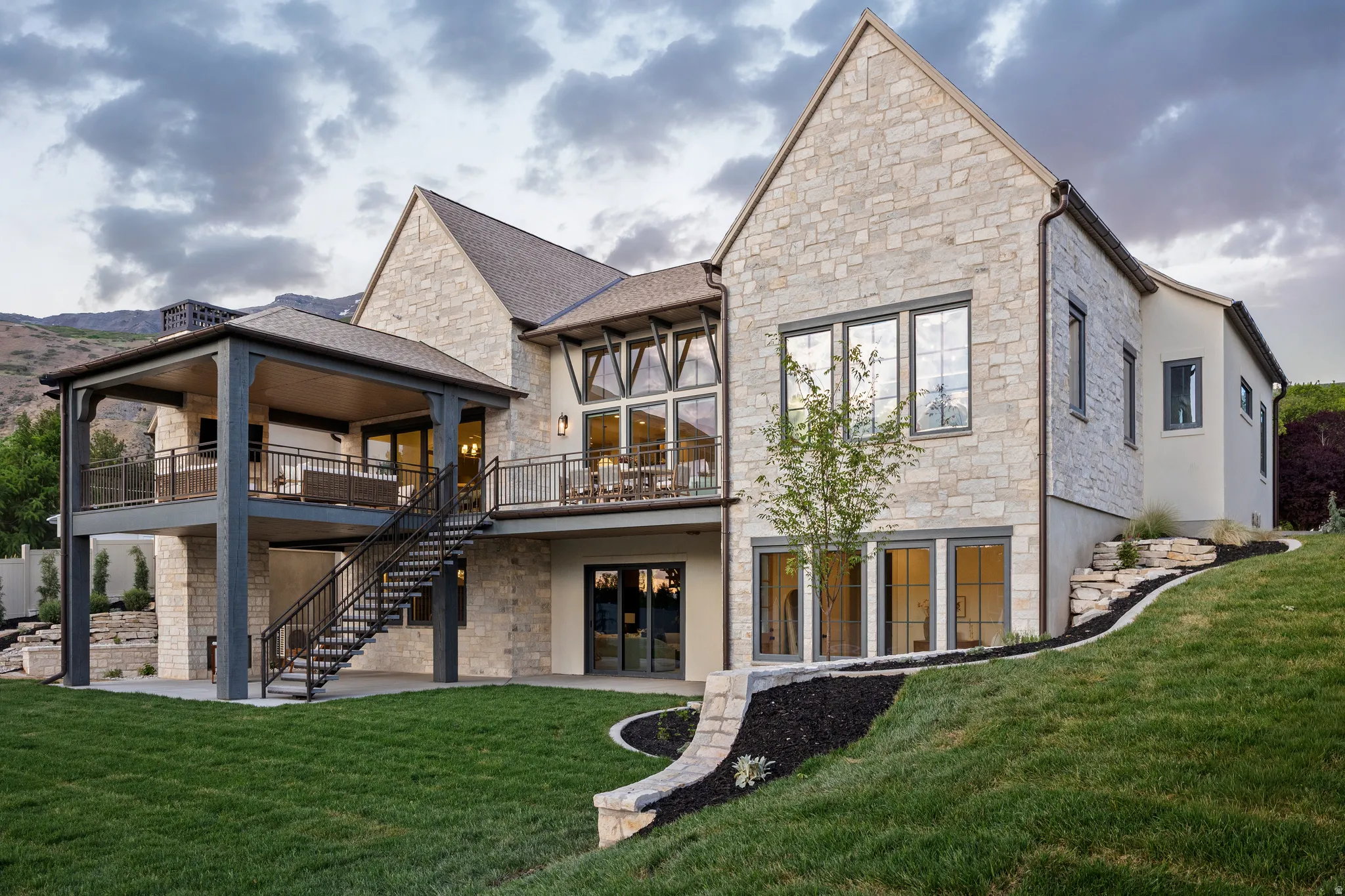 Stone and stucco exterior with multiple balconies and a covered patio