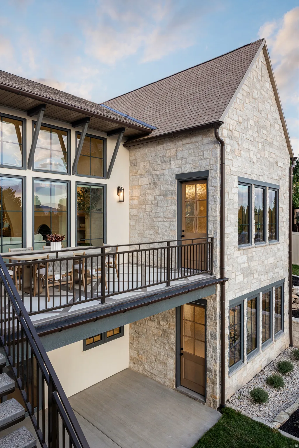 Stone and stucco exterior featuring multiple windows with dark trim