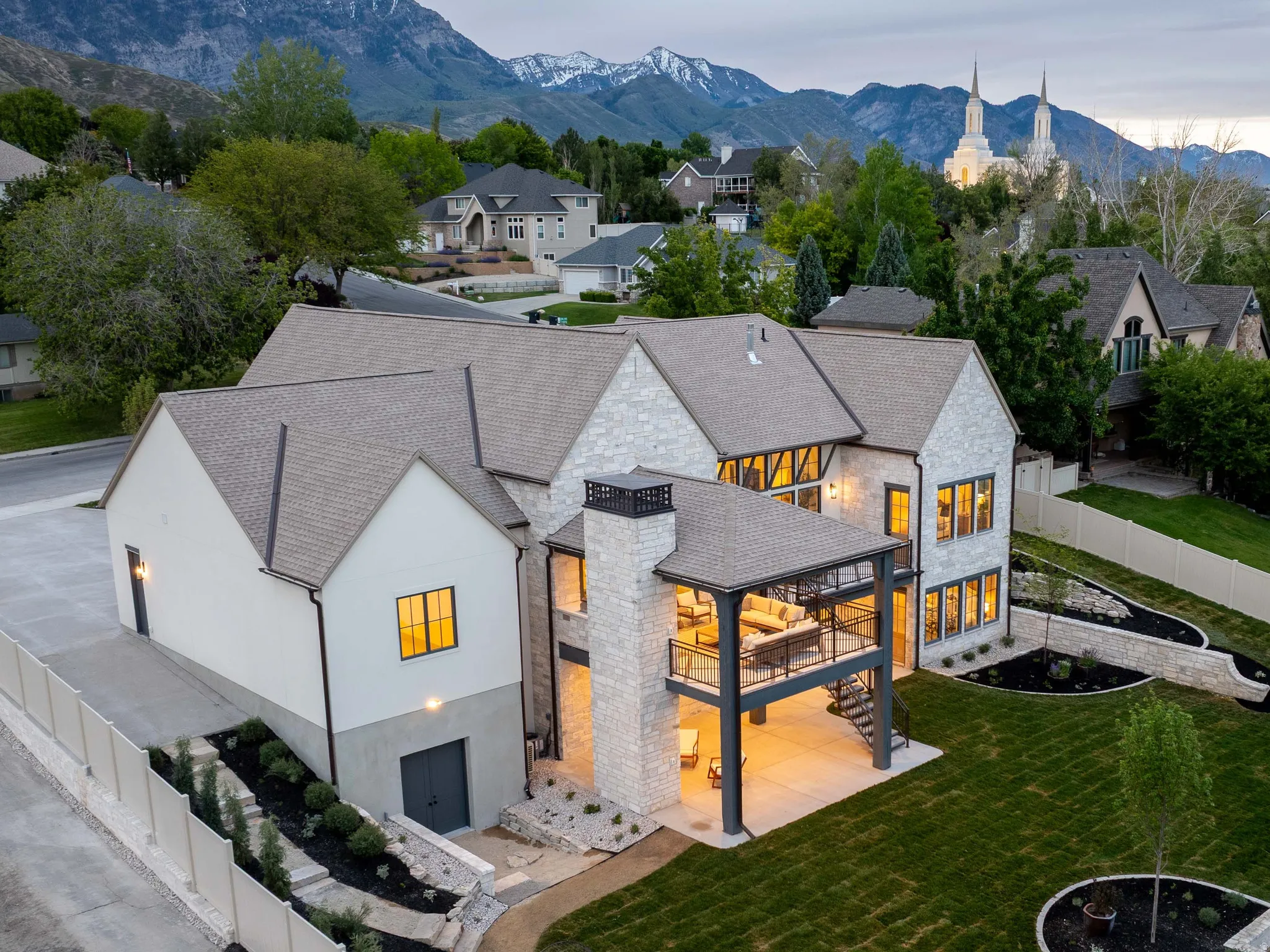 Contemporary residence featuring stone and stucco exterior, multiple gables, and a prominent chimney