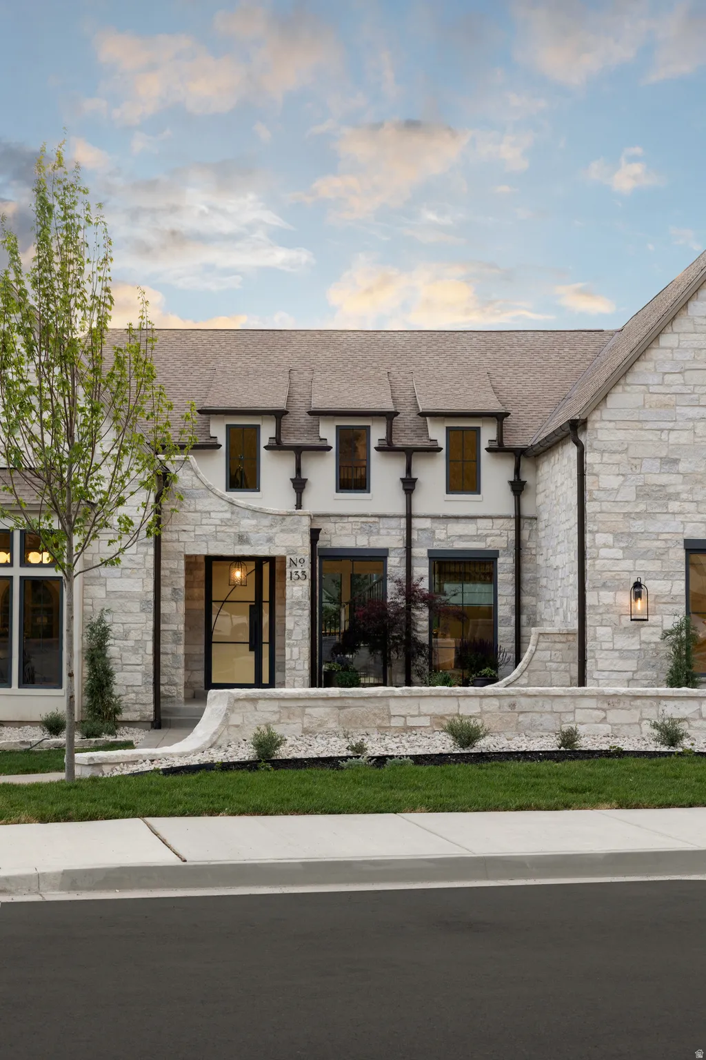 Stone and stucco exterior with multiple dormer windows