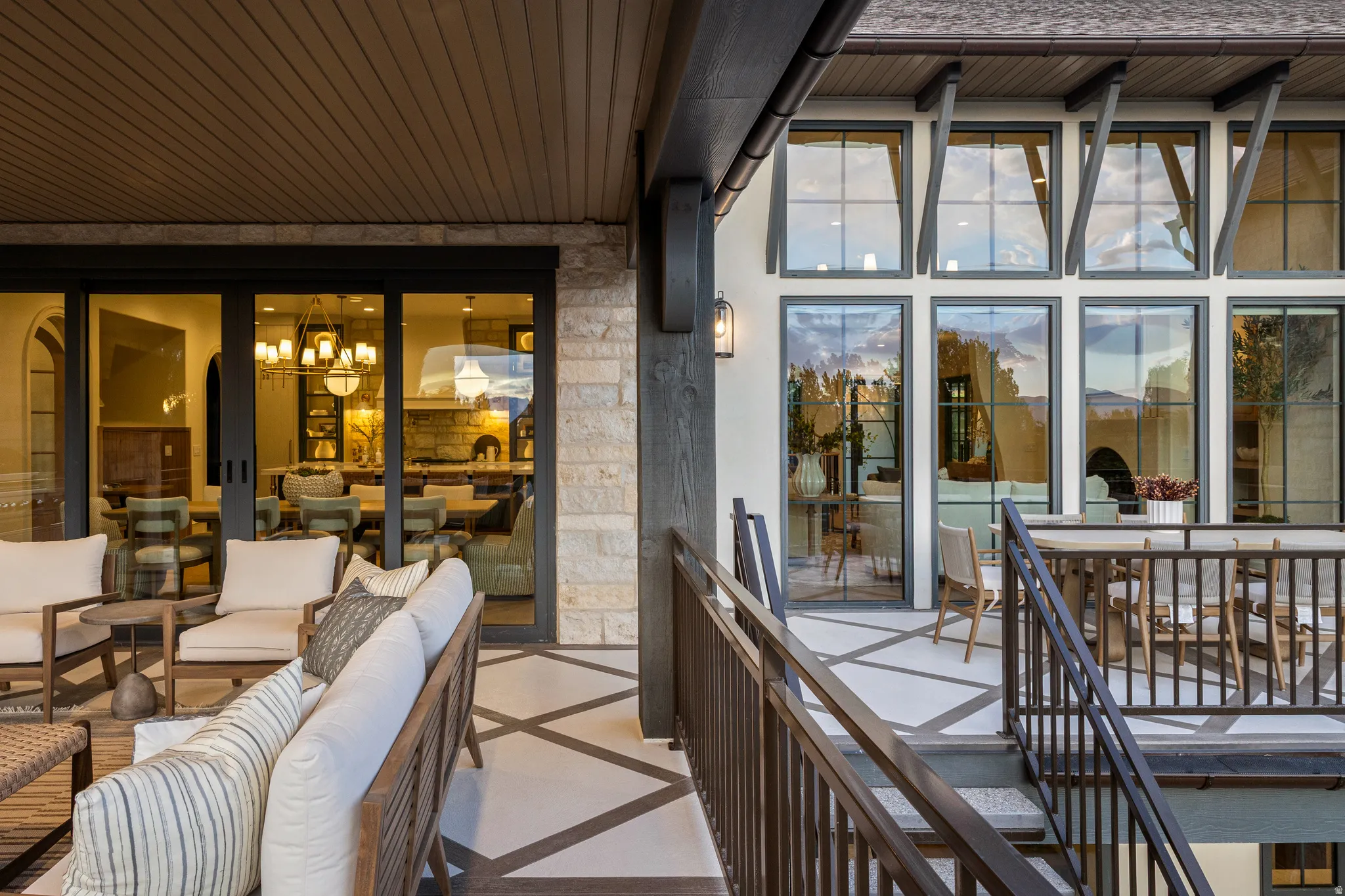 Expansive outdoor patio featuring a patterned floor, stone accent wall, and a wood-paneled ceiling