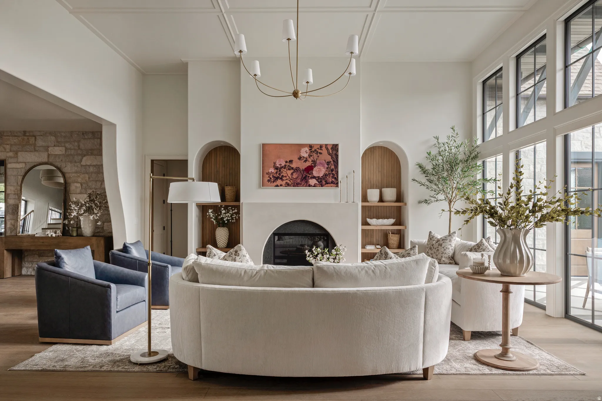 Living area with a floor-to-ceiling fireplace featuring an arched firebox and built-in arched alcoves with wood shelving