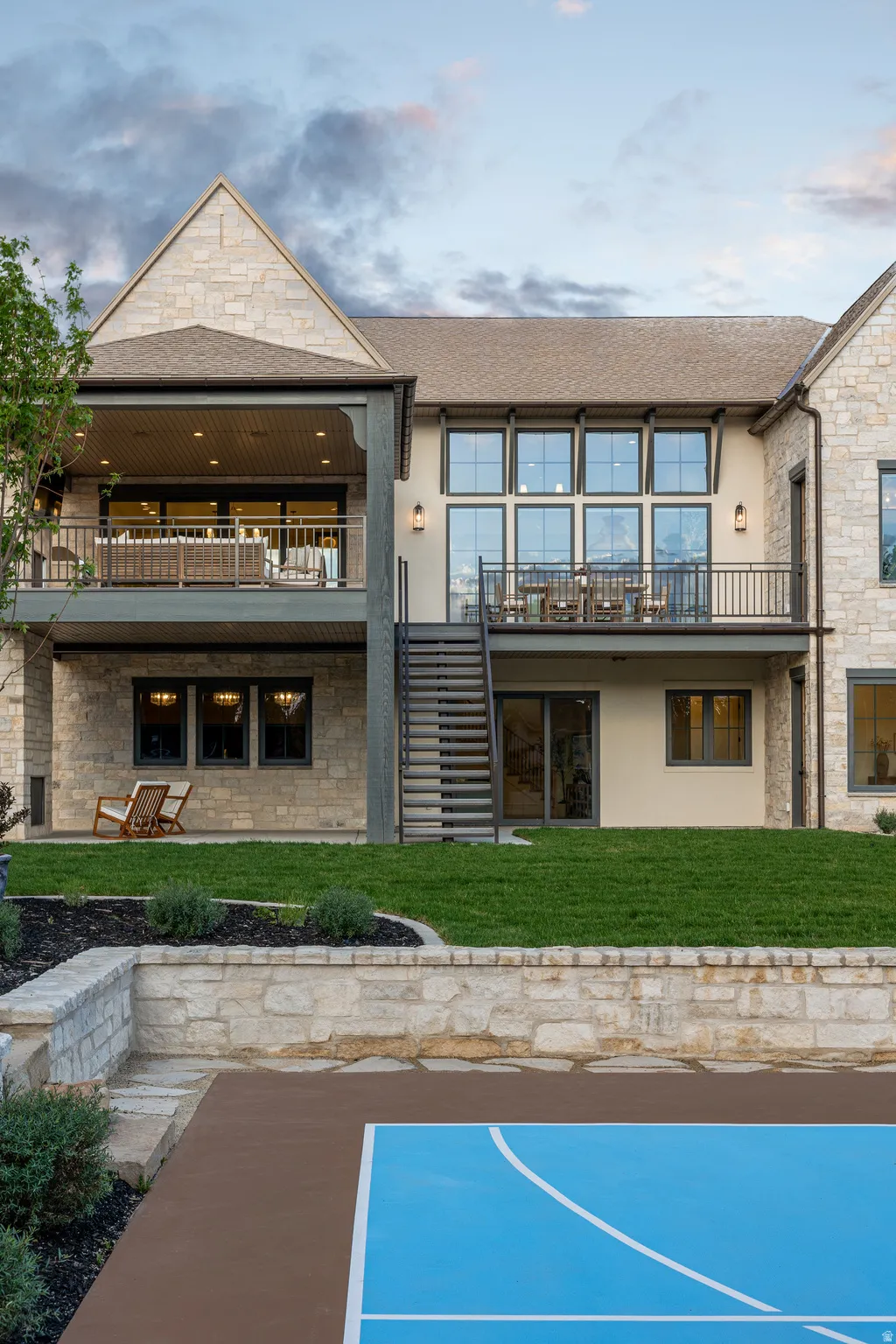 Stone veneer exterior with multiple balconies and a lower-level recreation area