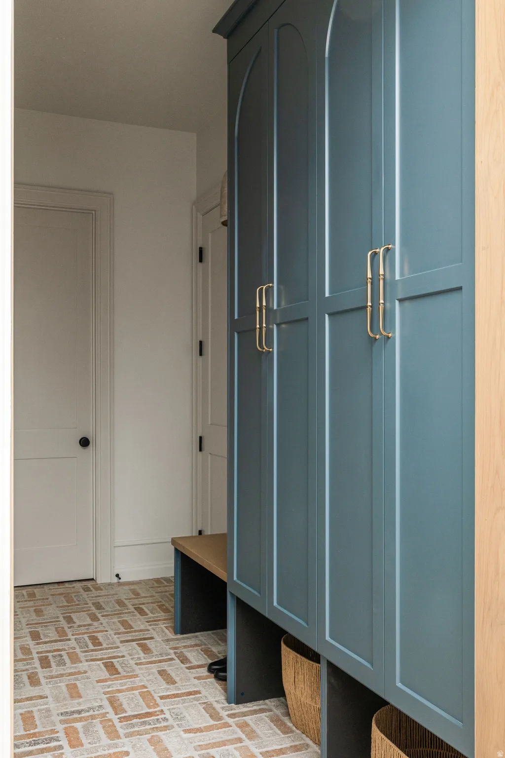 Built-in cabinetry featuring arched panels, gold-tone hardware, and a matte blue finish