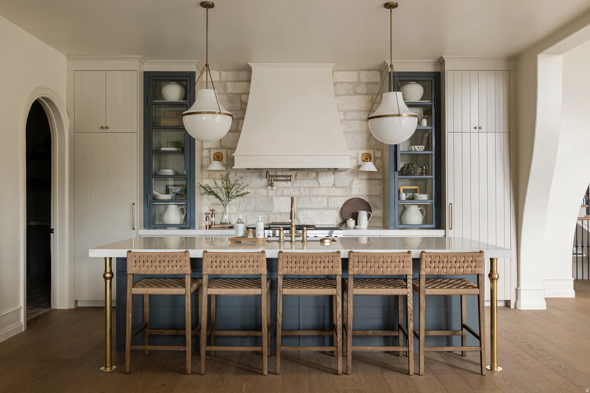 Central kitchen island with a stone countertop and seating for five