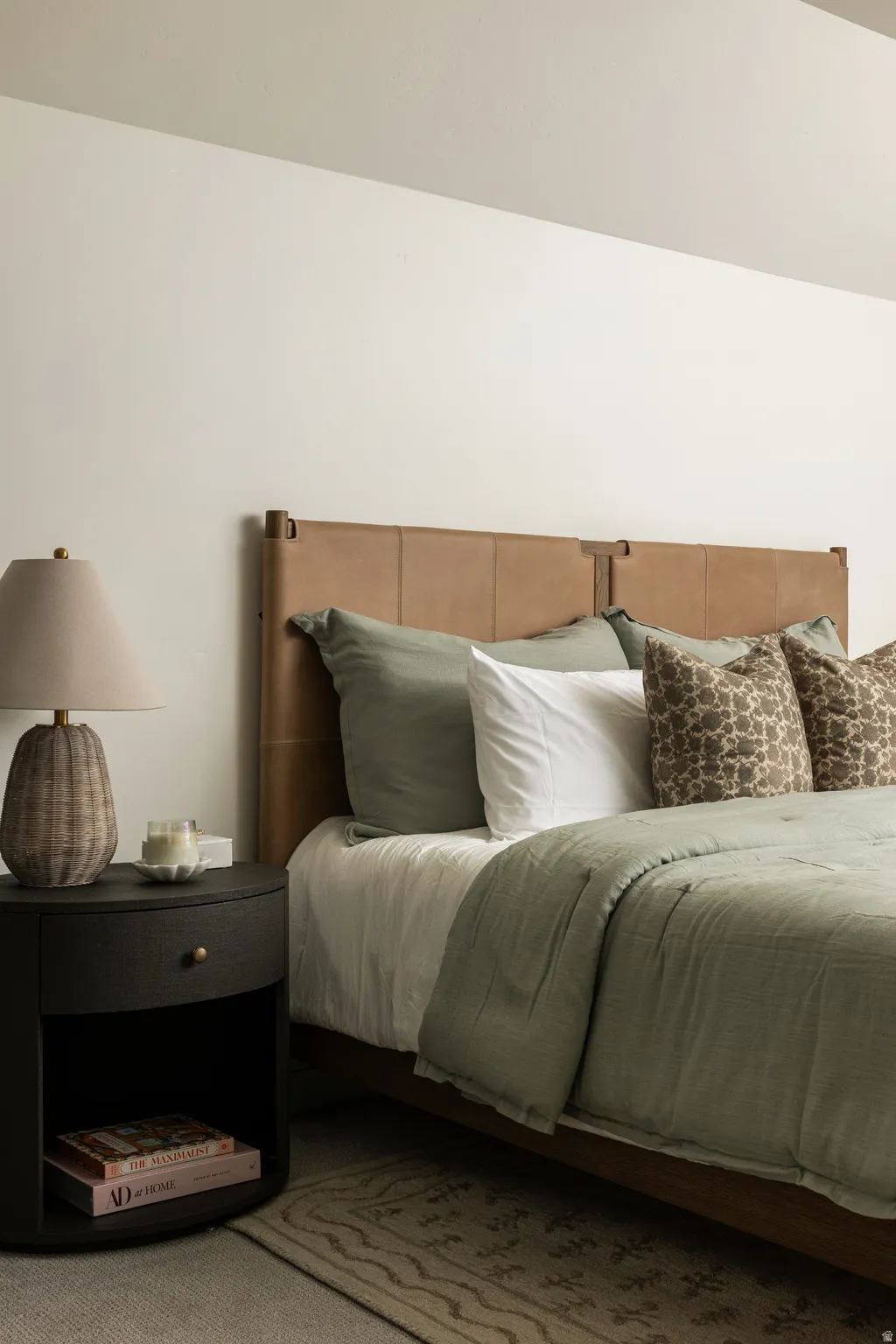 Cream-colored walls frame a bedroom featuring a tan leather headboard