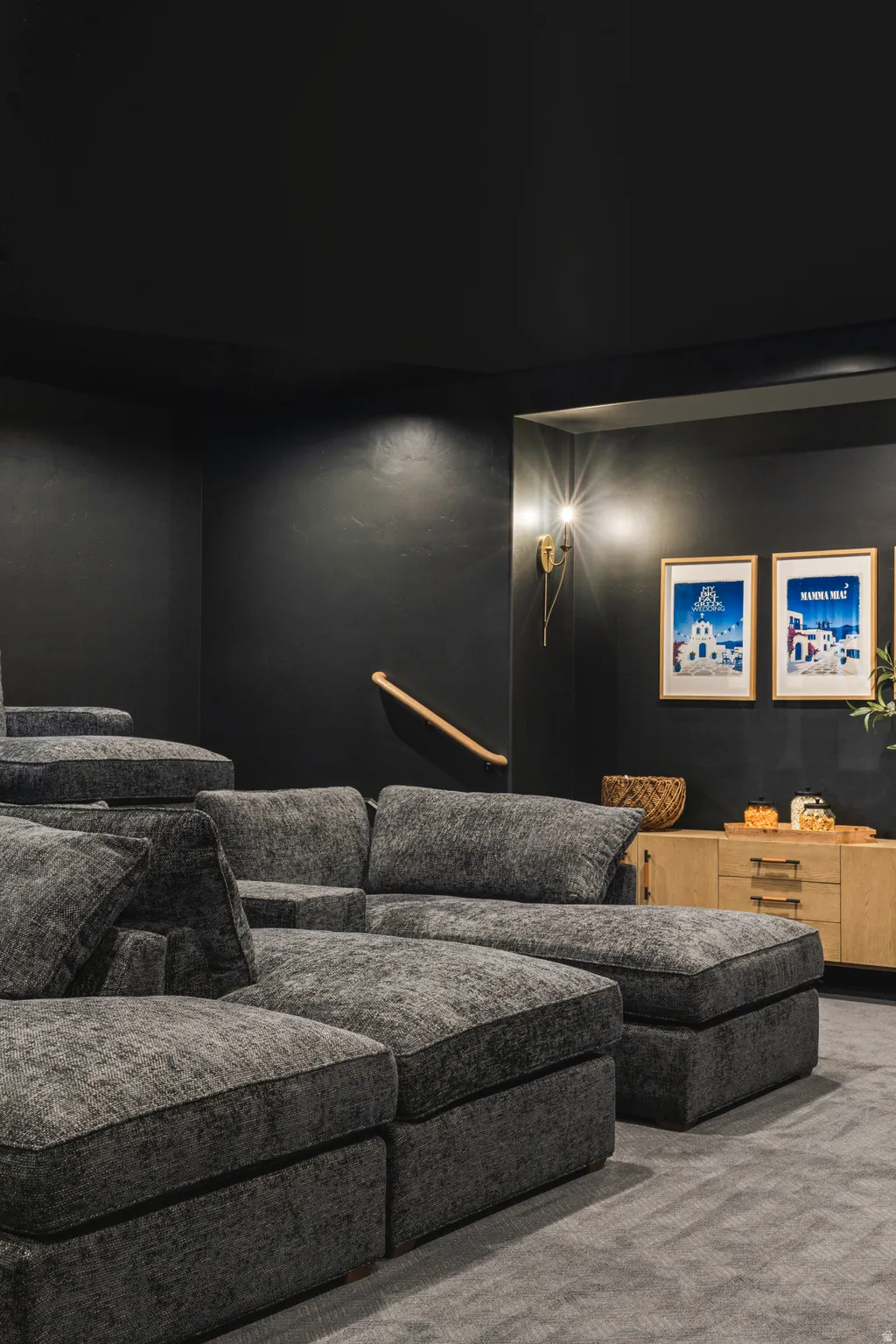 Dedicated entertainment space featuring tiered seating and plush, modular gray upholstery