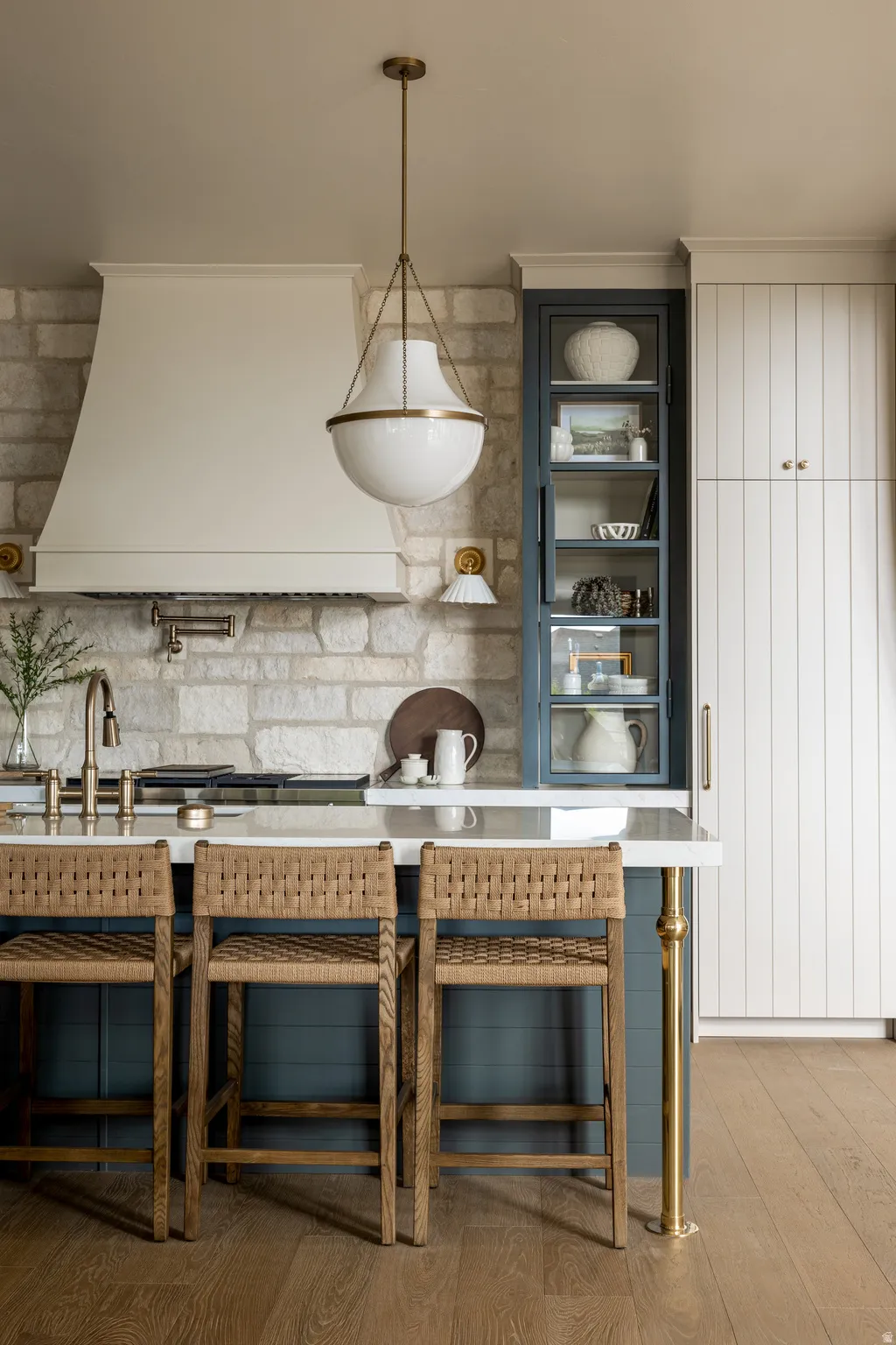 Kitchen featuring a stone backsplash, a custom range hood, and a central island with a white countertop