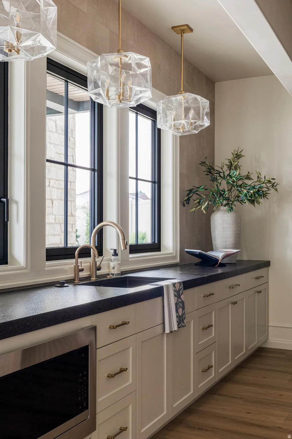Built-in cabinetry with neutral finish, dark countertop, and gold-toned hardware