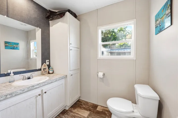 Bathroom vanity featuring an integrated sink, laminate countertop, and white cabinetry