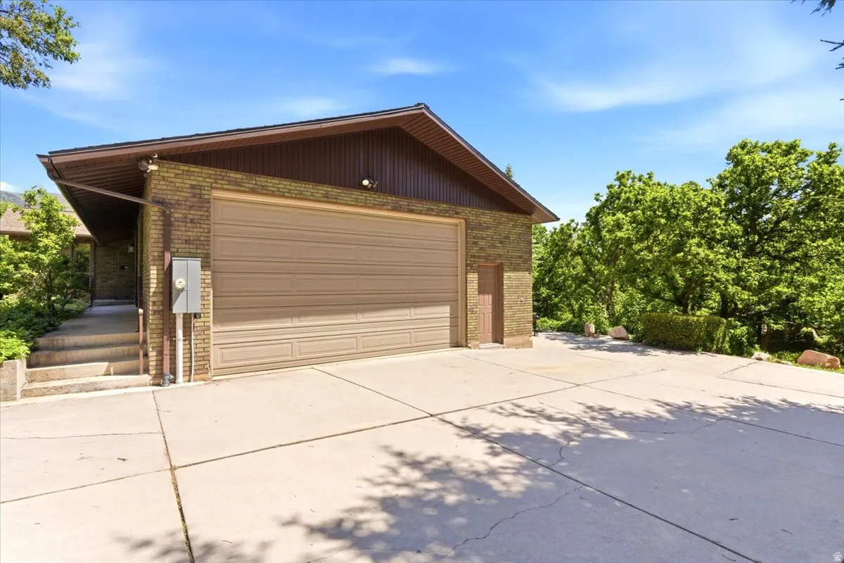 Abundant parking space with oversized extra-wide 2 car garage, 10 ft garage door, dedicated workshop space, utility sink, and large RV pad