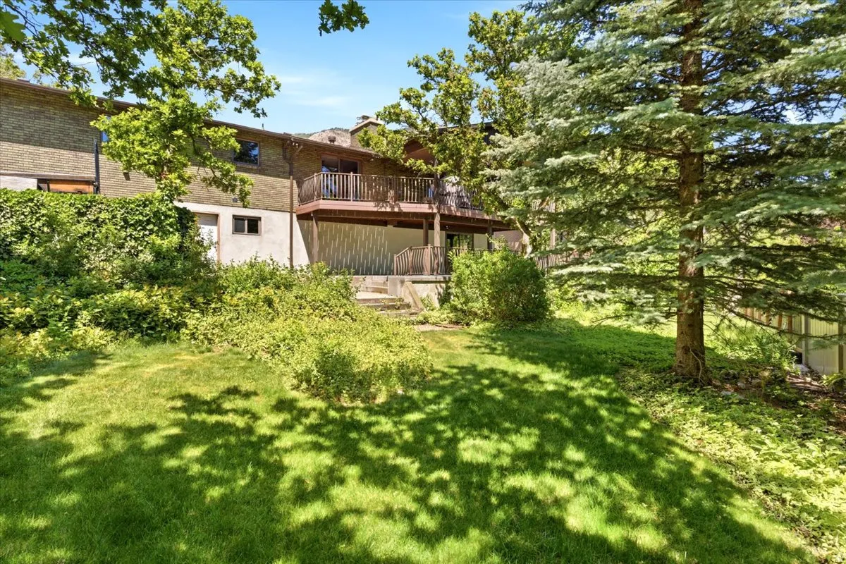 Backyard offers natural privacy & mature landscaping, huge TimberTech deck for entertaining, wrought iron railings, storage shed (new 2016), & auto sprinklers