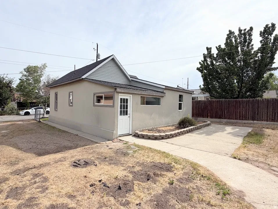 Stucco exterior with a peaked roofline and light gray siding accent