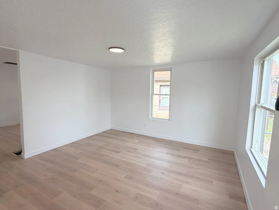 Bright interior space featuring light wood-finish flooring, white walls, and white trim