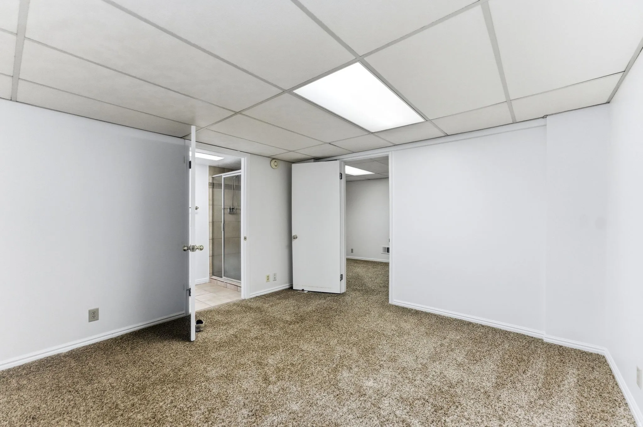 Room featuring neutral-toned carpet flooring and white painted walls