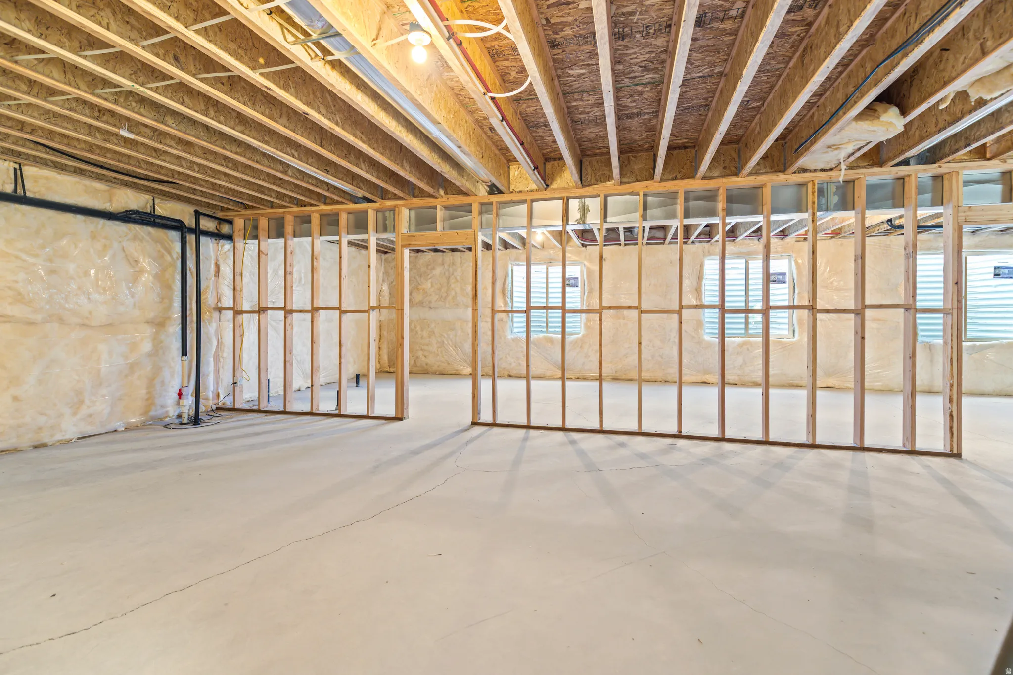 Unfinished basement offering expansive open space and structural framing for future build-out
