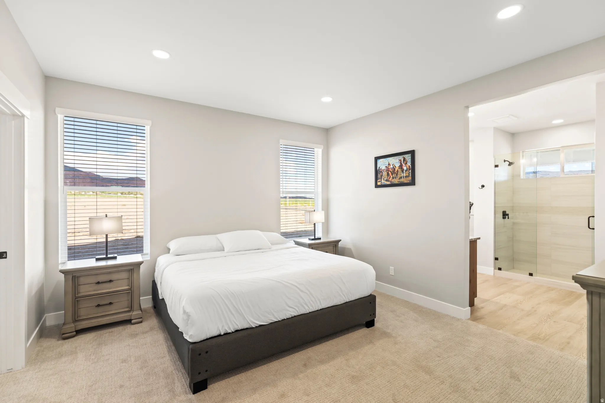 Spacious bedroom featuring light-colored carpet flooring and recessed lighting