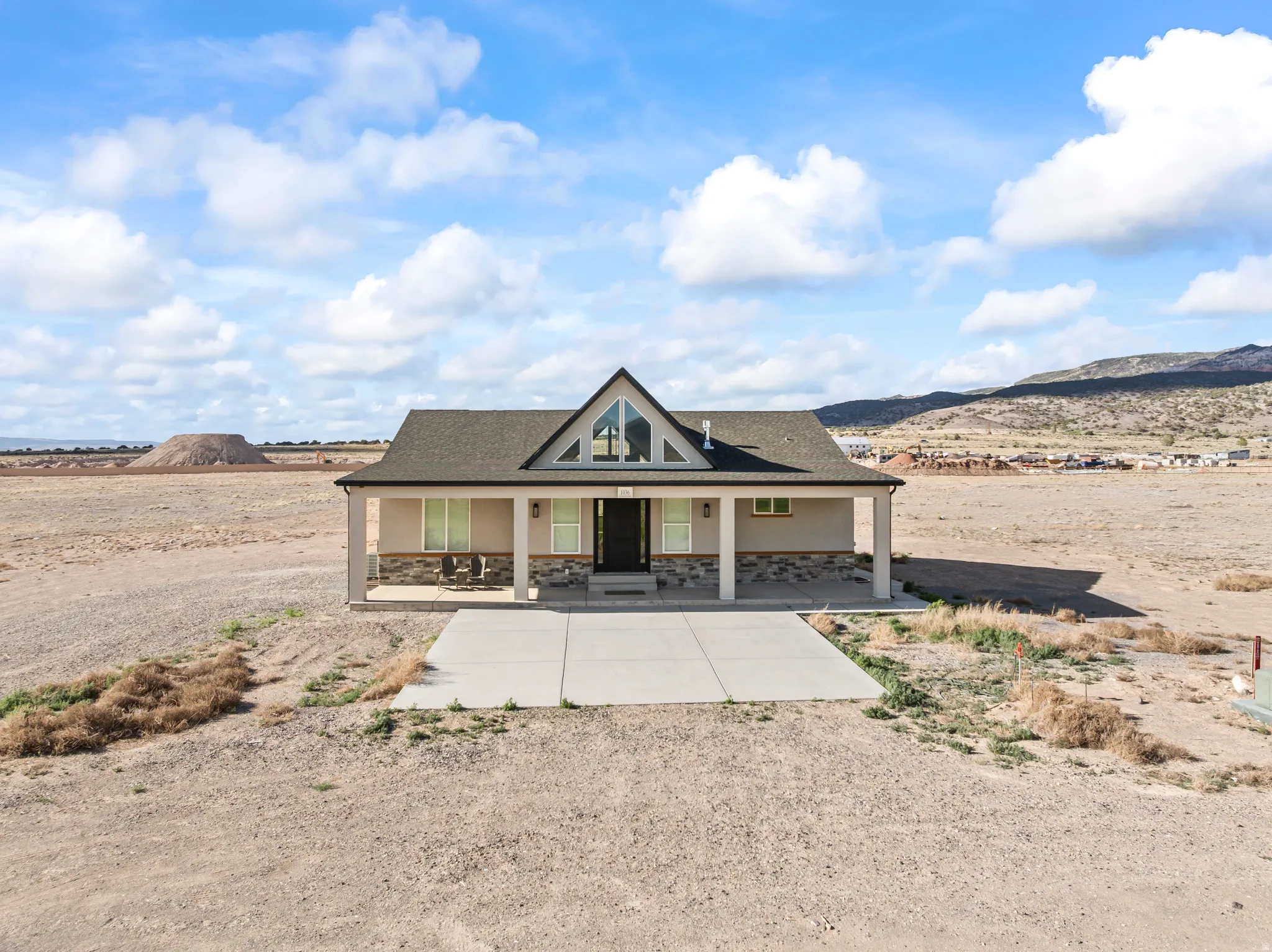 Contemporary home with a peaked roofline, front porch, and a two-car concrete driveway
