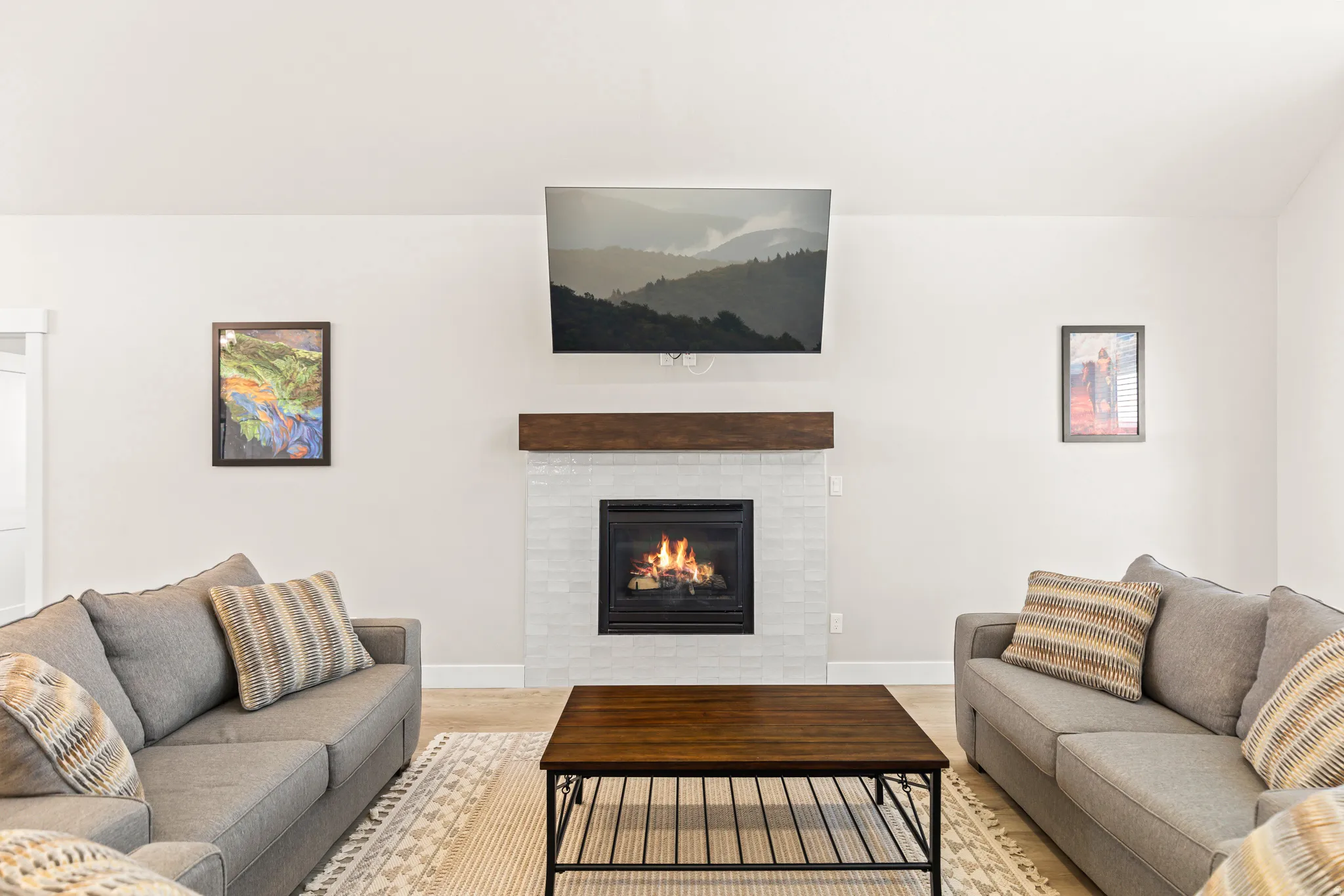 Centrally located gas fireplace featuring a tile surround and a wood mantel