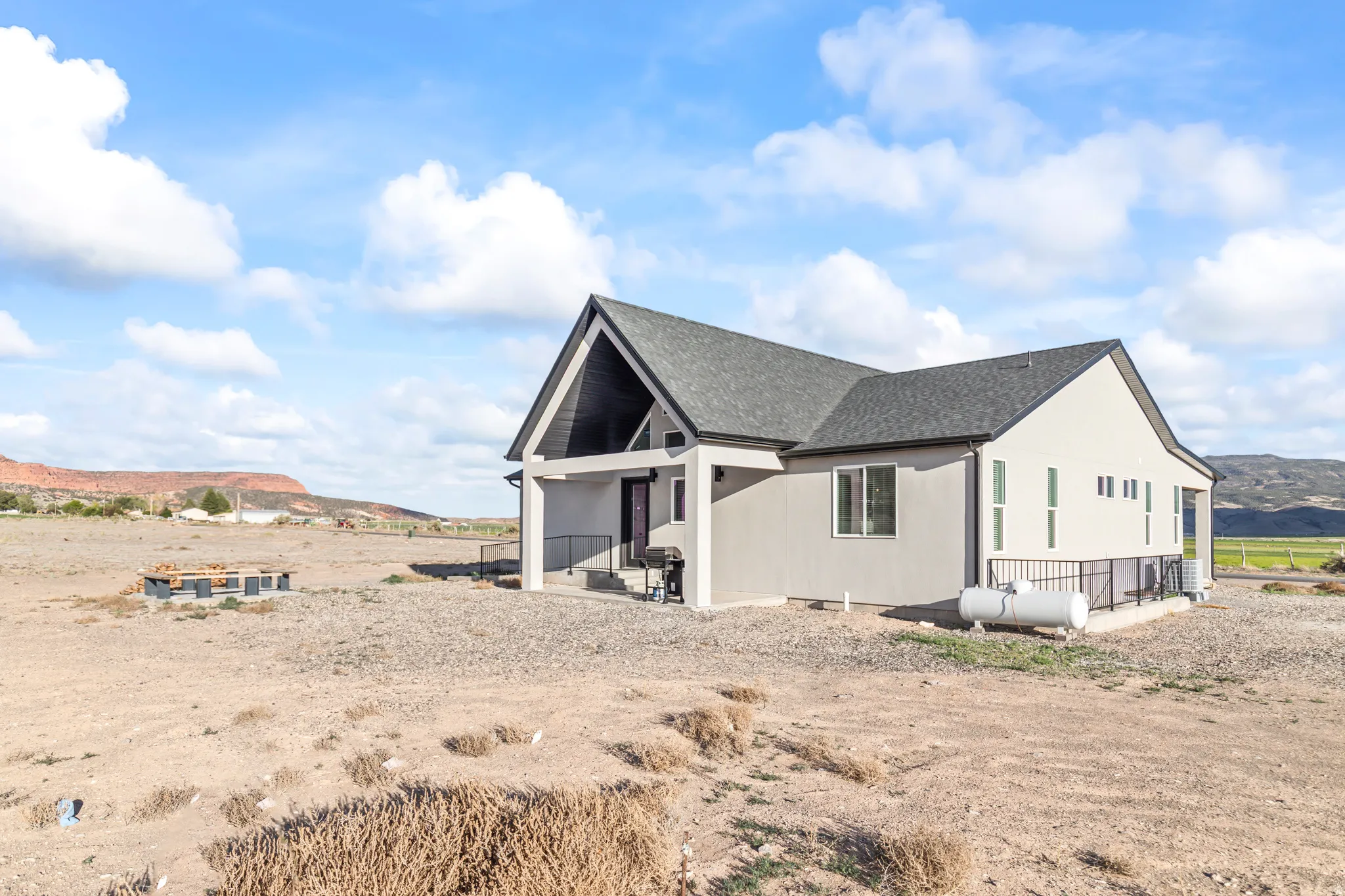 Contemporary-style residence with a dark gray shingle roof and light gray stucco exterior