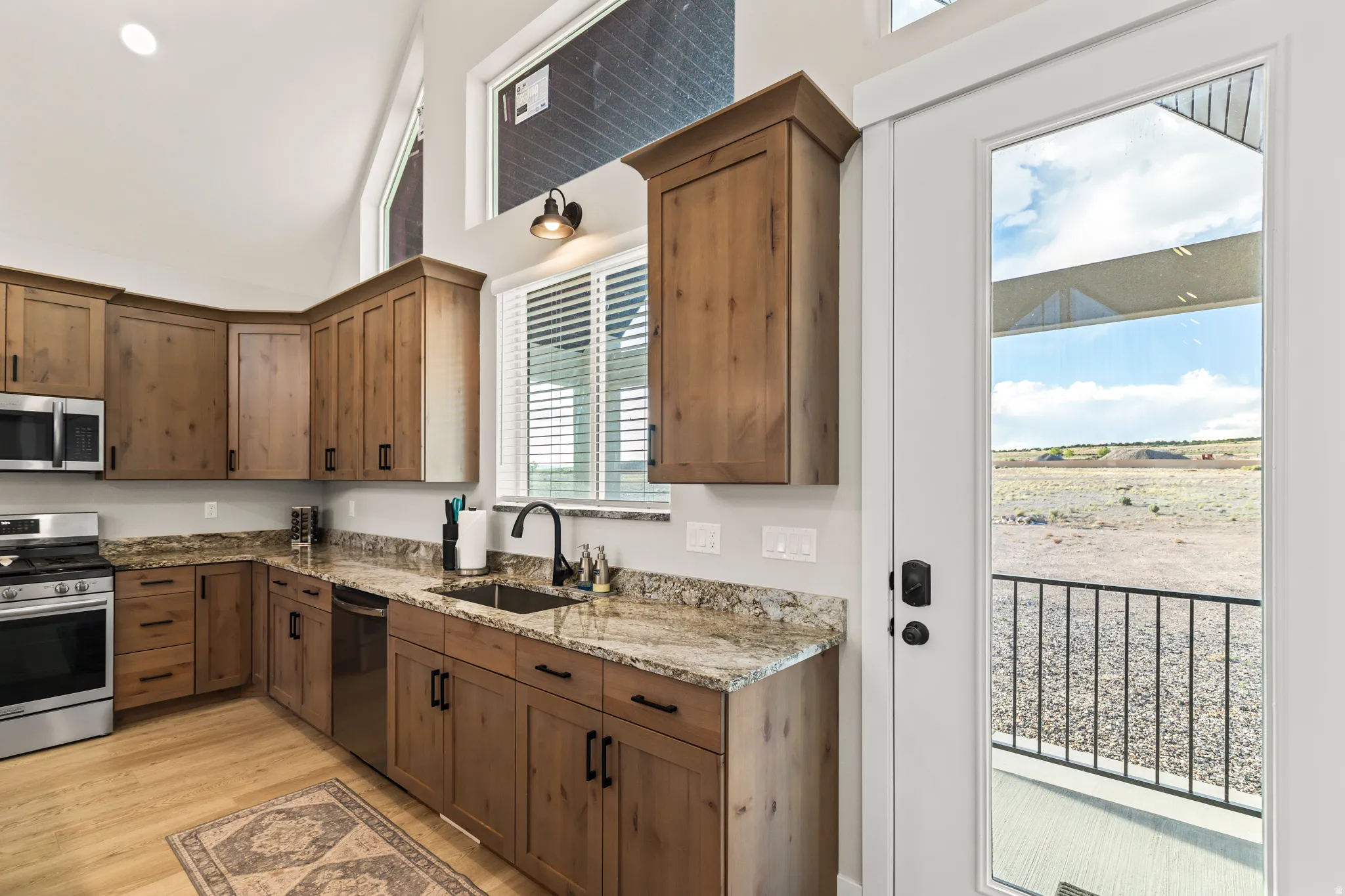 Kitchen featuring wood-finish cabinetry, granite countertops, stainless steel appliances, and a gas range