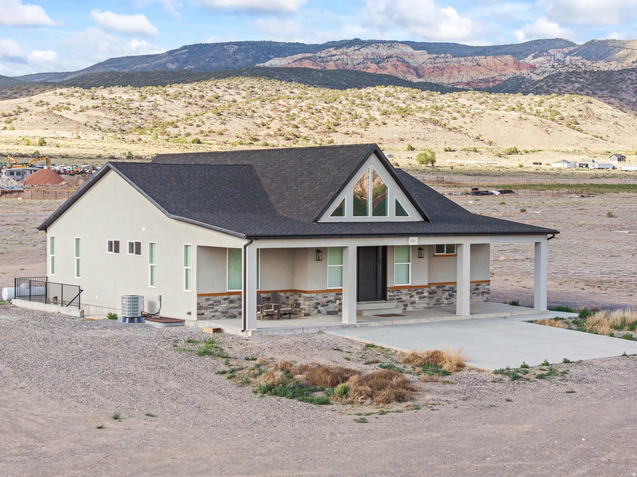 Ranch-style residence featuring a covered front porch, stone accents, and a gabled roofline