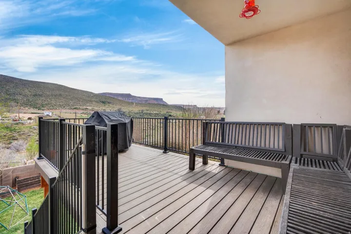 Spacious outdoor deck featuring wood-finish composite decking and black metal railings