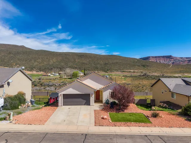 Single-story residence featuring a two-car garage, front yard with green patch and decorative rock landscaping, and a low-maintenance exterior