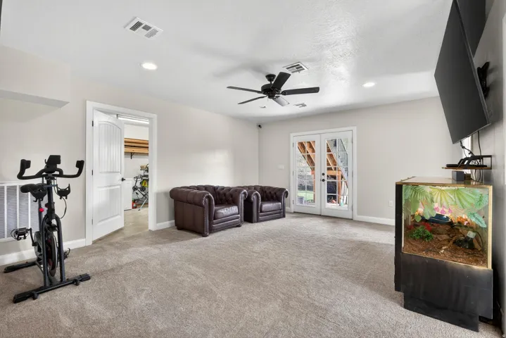 Spacious room featuring neutral carpeting, recessed lighting, and a ceiling fan